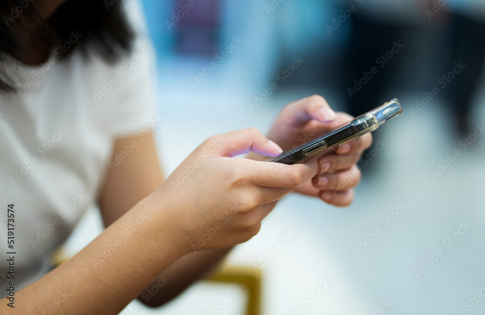 Close up of young woman using smartphone at cafe.