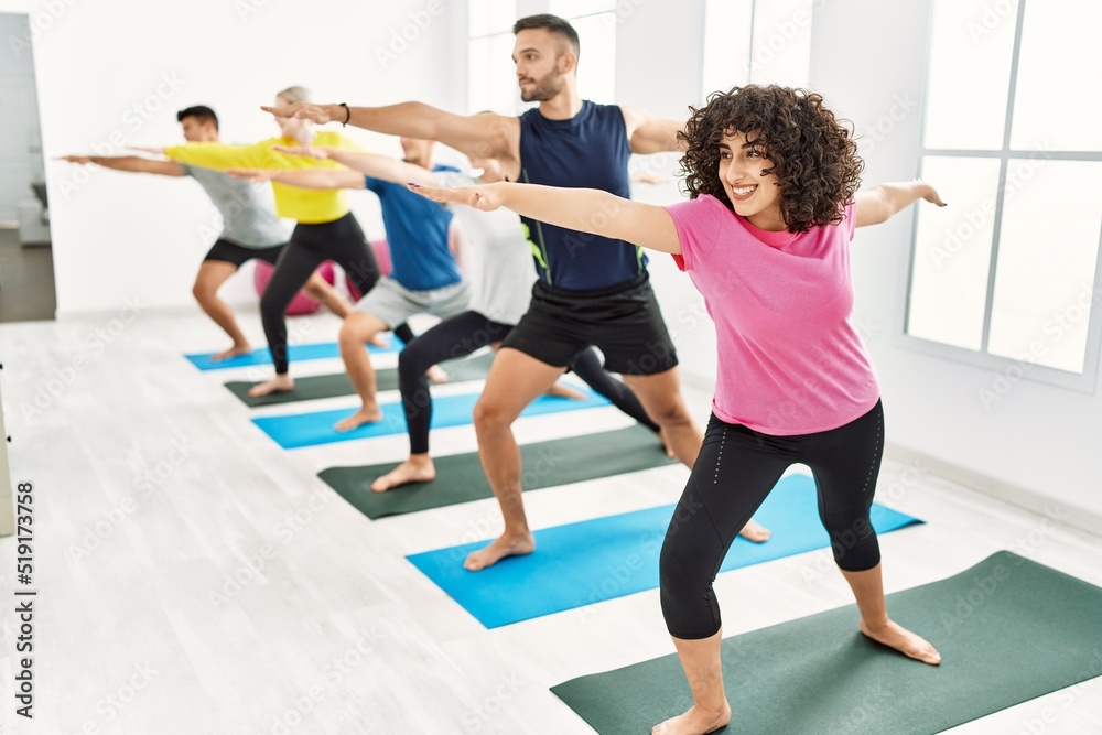 Group of young people smiling happy training yoga at sport center. Group of young people smiling happy training yoga at sport center.