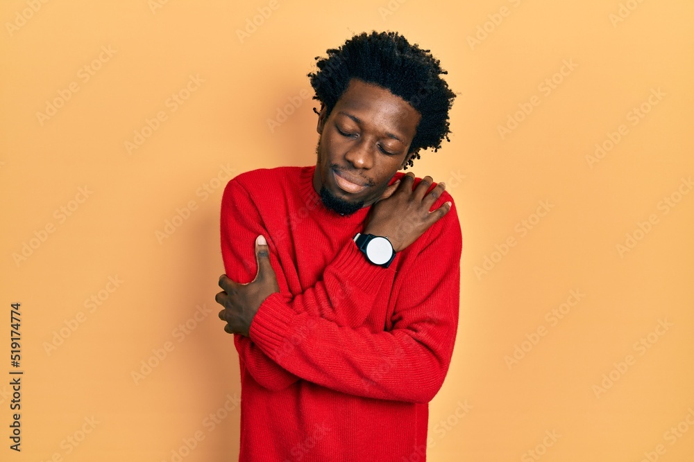Young african american man wearing casual clothes hugging oneself happy and positive, smiling confident. self love and self care Young african american man wearing casual clothes hugging oneself happy and positive, smiling confident. self love and self care