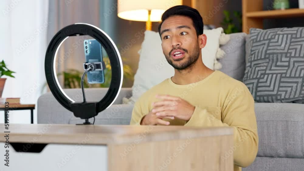 Influencer recording a video on a phone at home. Young man creating content and live streaming a broadcast online for a vlog channel. Guy filming a podcast while speaking to followers on social media
