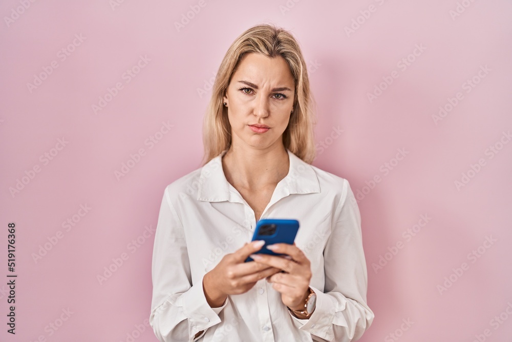 Young caucasian woman using smartphone typing message depressed and worry for distress, crying angry and afraid. sad expression.