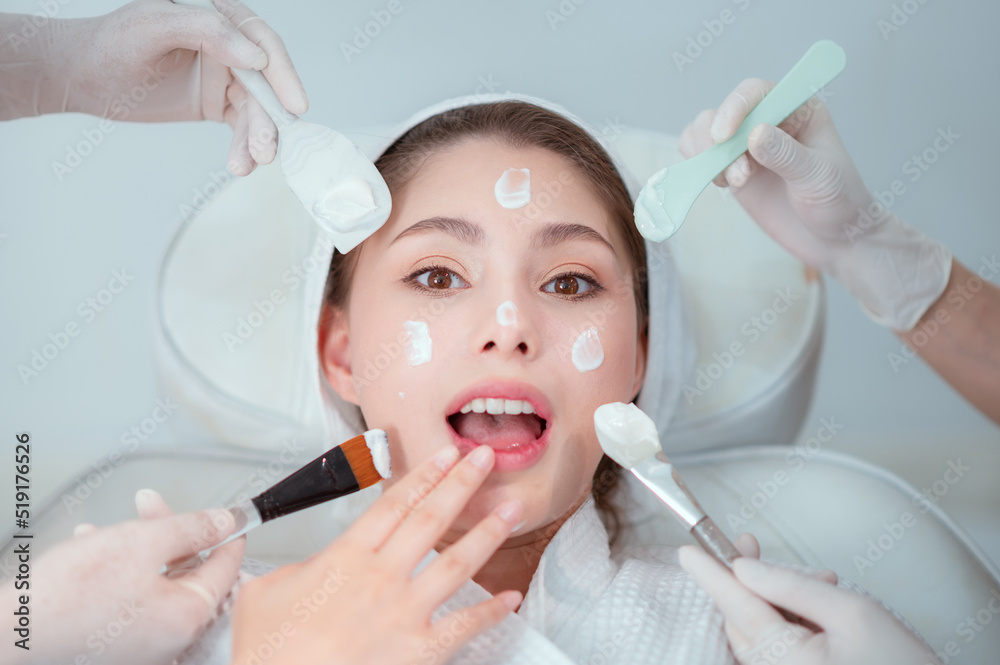 Naklejka premium Happy female face of young women who do cosmetic surgery and apply facial cream