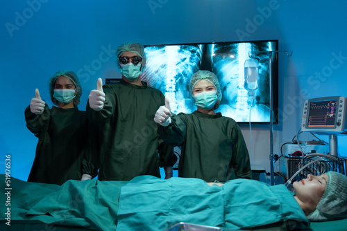 Confident team of surgeons in scrubs, caps and face masks standing with their arms folded and looking at camera © 2B