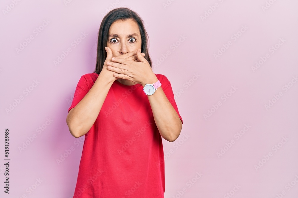 Middle age hispanic woman wearing casual clothes shocked covering mouth with hands for mistake. secret concept. Middle age hispanic woman wearing casual clothes shocked covering mouth with hands for mistake. secret concept.
