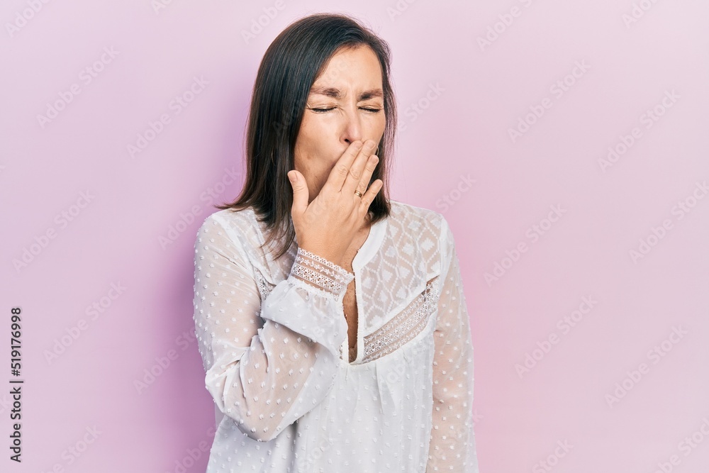 Middle age hispanic woman wearing casual clothes bored yawning tired covering mouth with hand. restless and sleepiness. Middle age hispanic woman wearing casual clothes bored yawning tired covering mouth with hand. restless and sleepiness.