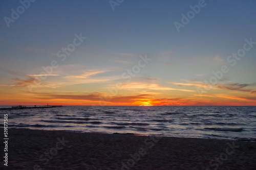 Colorful orange sunset over Baltic sea on clear summer day