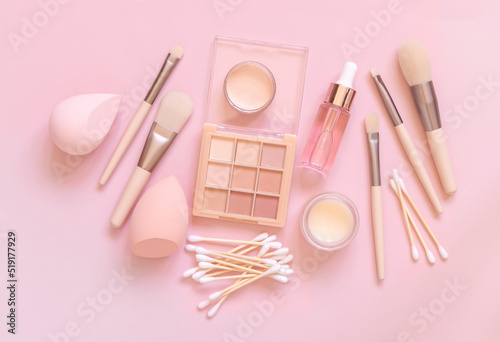 Natural beige eye shadow and decorative cosmetics on light pink, top view