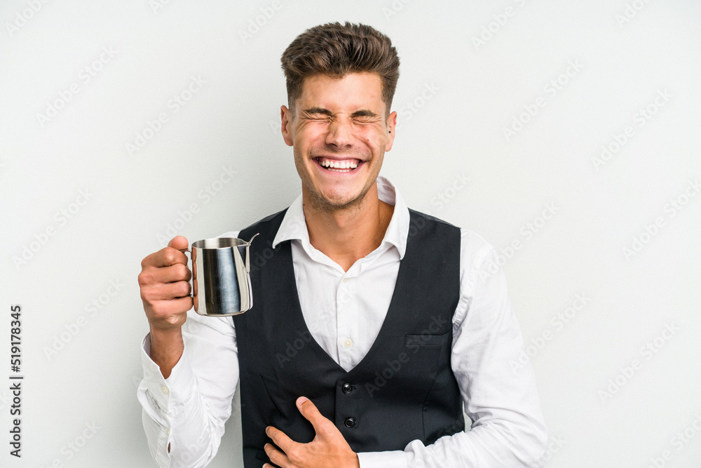 Young caucasian barista man isolated on yellow background laughing and having fun. Young caucasian barista man isolated on yellow background laughing and having fun.