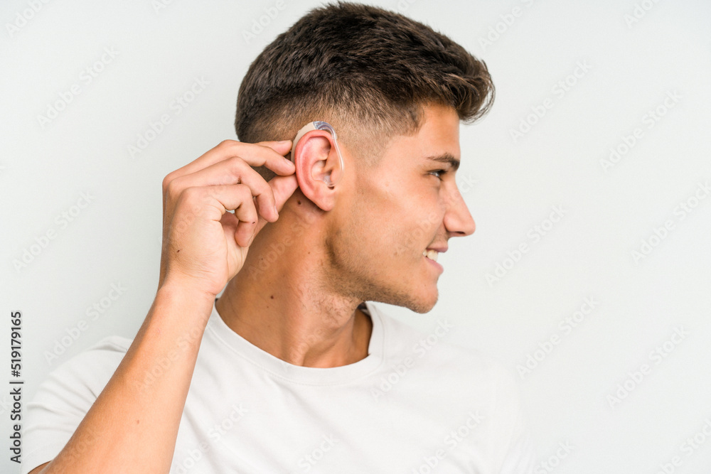 Young caucasian man wearing a hearing aid isolated on white background Young caucasian man wearing a hearing aid isolated on white background