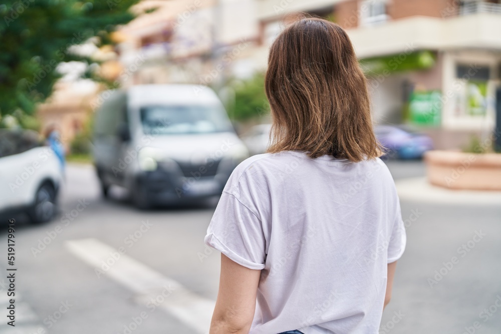 Fototapeta premium Young woman standing on back view at street