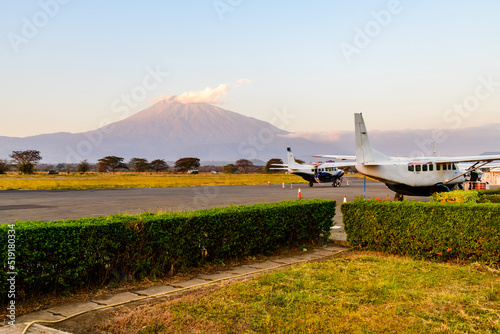 Small propeller airplanes at the airport at sunset, mount Meru at background. Arusha, Tanzania