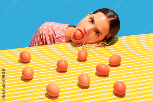 Creative funny image of young woman and eggs on bright yellow tablecloth isolated on blue background. Household photo