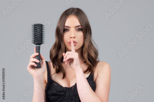 Young woman hairdresser with comb brushing hair. Brunette woman combing hair.