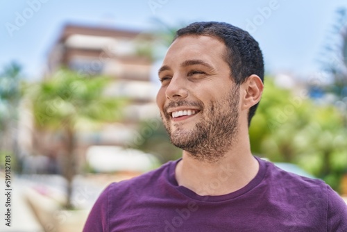 Young man smiling confident looking to the side at street