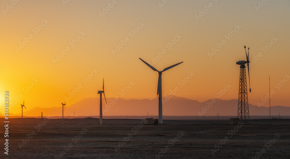 Obraz premium Wind power plants in desert at sunset