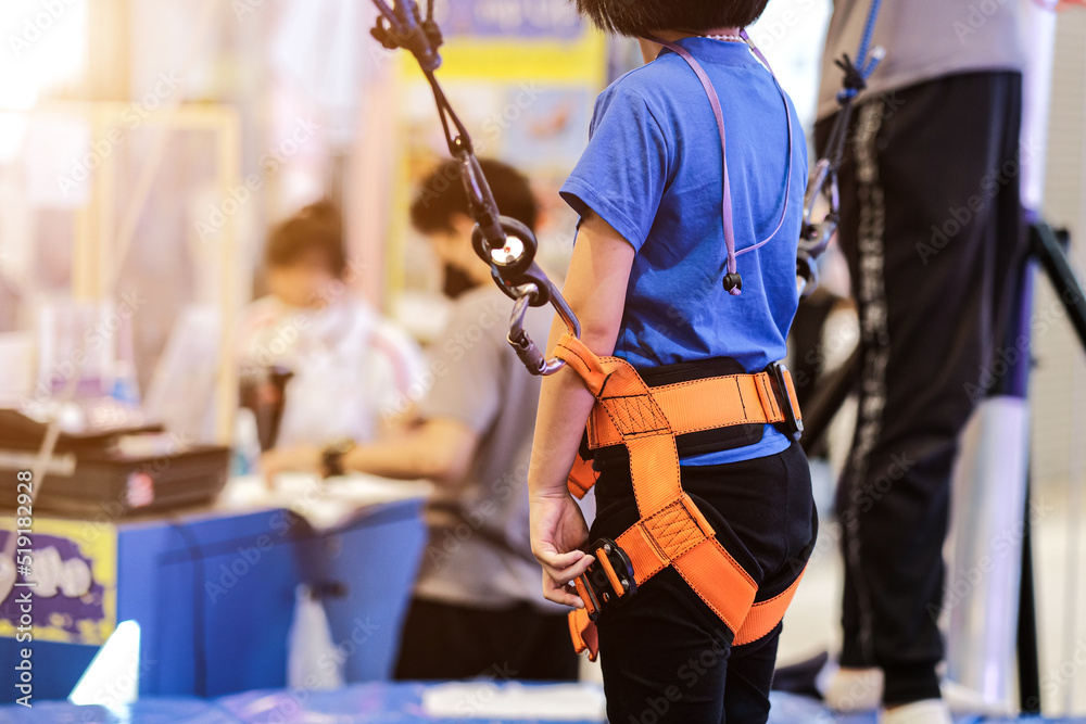 little boy climbing a rock wall indoor, Kid climbing the wall outdoors, Active leisure time with children concept, Little boy in a rope park.