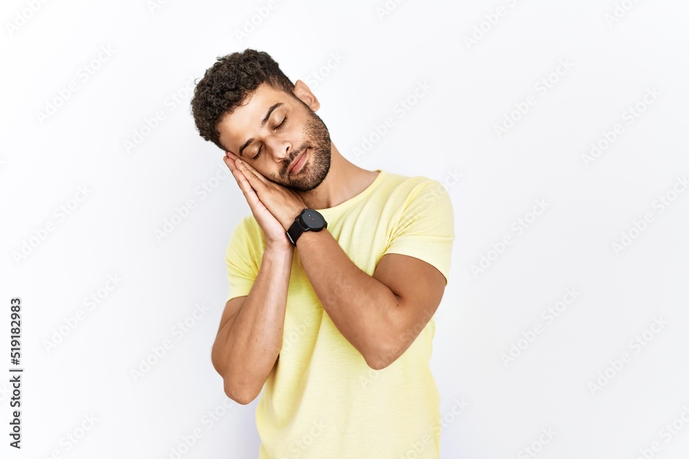 Arab young man standing over isolated background sleeping tired dreaming and posing with hands together while smiling with closed eyes. Arab young man standing over isolated background sleeping tired dreaming and posing with hands together while smiling with closed eyes.