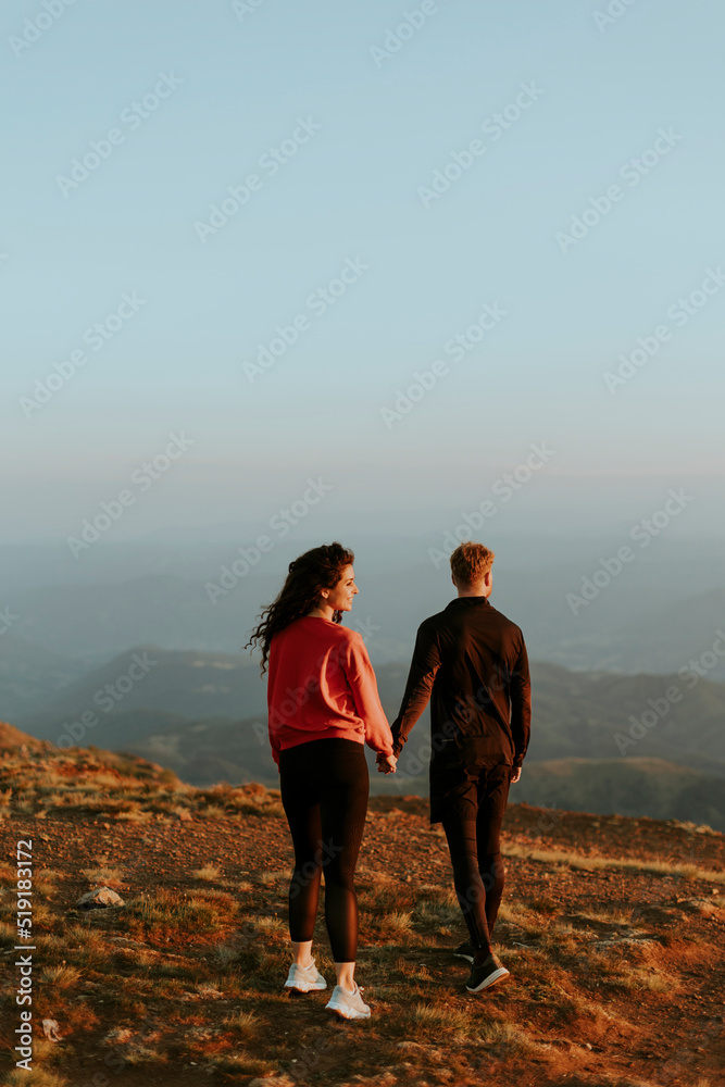Young couple traveling together and hiking in the mountains