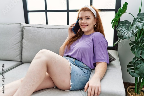 Young redhead woman smiling confident talking on the smartphone at home