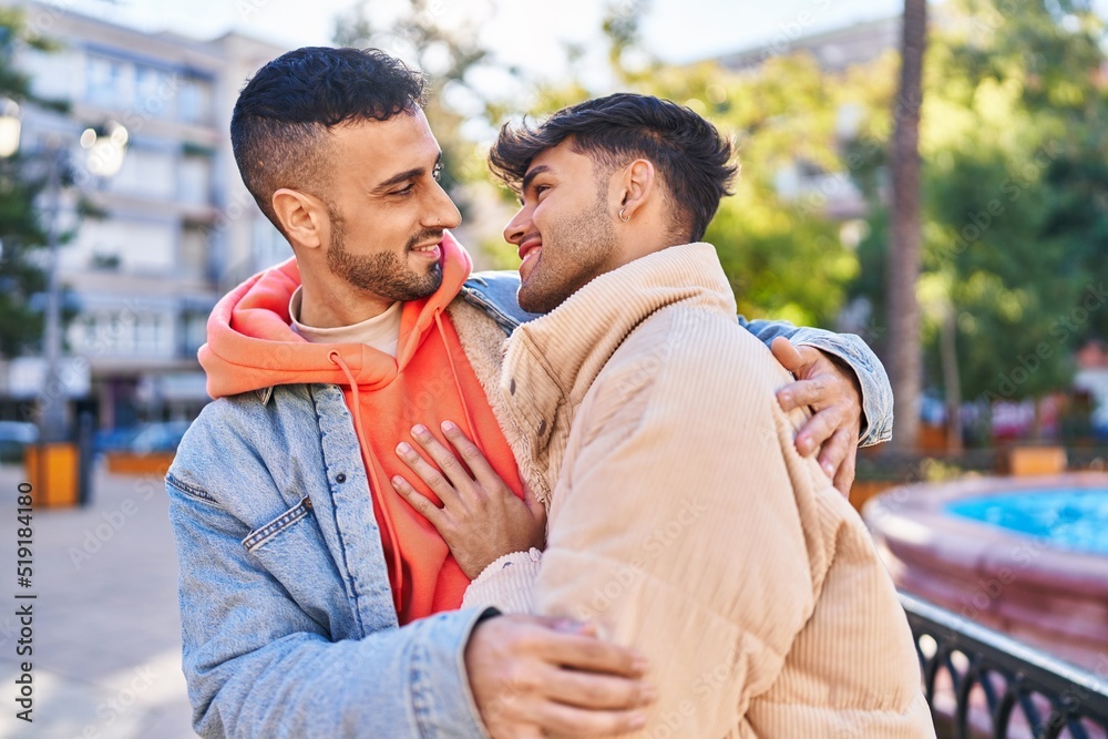 Fototapeta premium Two man couple hugging each other standing at park