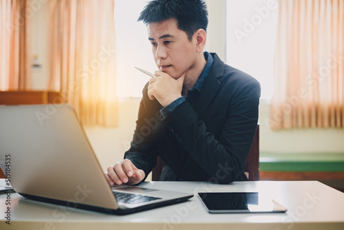 Creative office : Young asian businessman working on table computer. Busy millennial and stressful start up business person work in office.