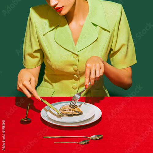 Fotografia Cropped image of woman eating oyster on red tablecloth isolated over green background
