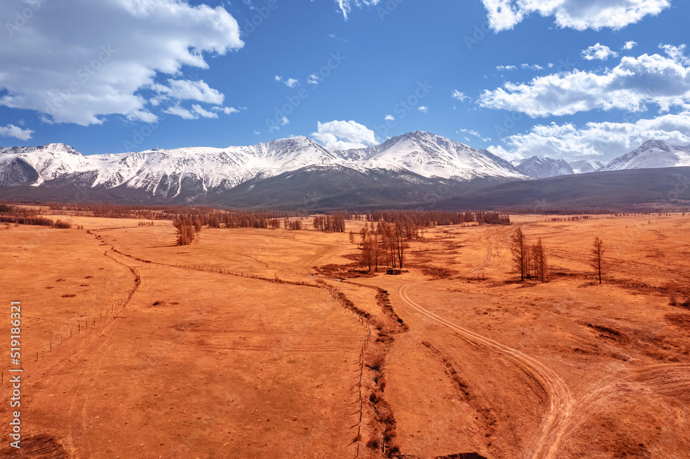 Beautiful landscape road in autumn forest with snow peaks mountains Chuysky tract, Altai Kurai steppe Russia. Aerial top view