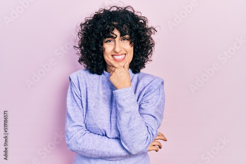 Young middle east woman wearing casual clothes looking confident at the camera smiling with crossed arms and hand raised on chin. thinking positive. © Krakenimages.com
