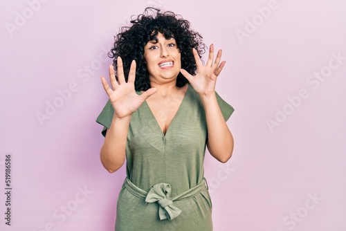 Young middle east woman wearing casual clothes afraid and terrified with fear expression stop gesture with hands, shouting in shock. panic concept.