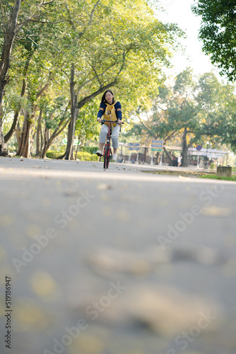 Wallpaper Mural asian woman biking bicycle with her cat in backpack at park Torontodigital.ca