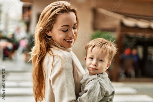 Beautiful family of mother and baby son hugging and bonding together with love. Parent and toddler outdoors