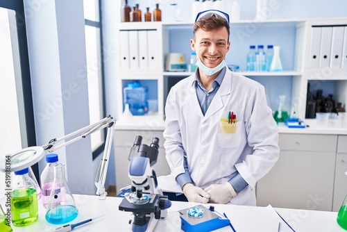 Caucasian man working at scientist laboratory with a happy and cool smile on face. lucky person.