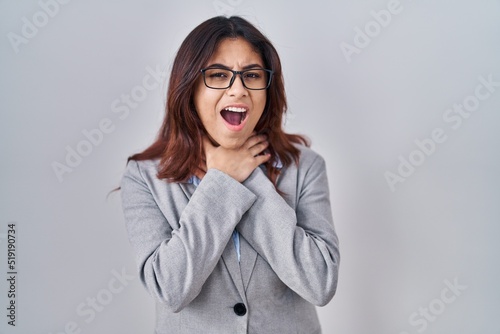 Hispanic young business woman wearing glasses shouting and suffocate because painful strangle. health problem. asphyxiate and suicide concept.