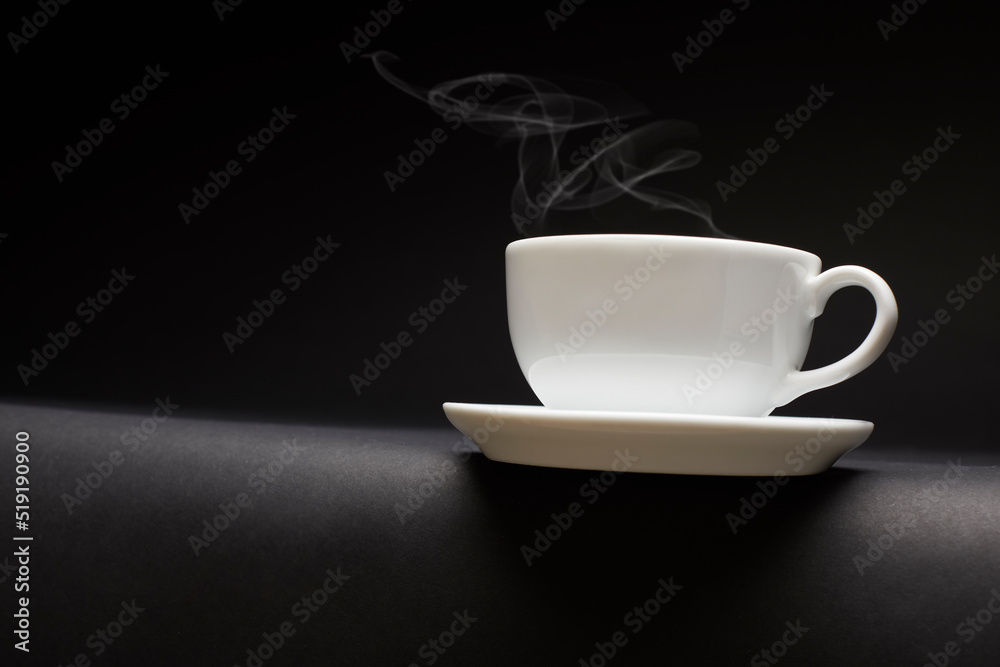 White ceramic coffee cup with steam on black table. White ceramic coffee cup with steam on black table.