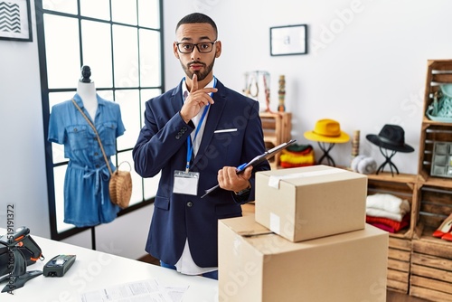 African american man working as manager at retail boutique thinking concentrated about doubt with finger on chin and looking up wondering © Krakenimages.com