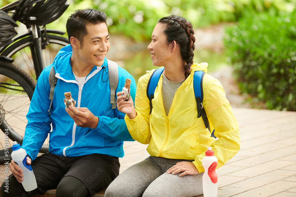 © DragonImages - Happy young couple eating energy bars after bicycle ride to get more energy © DragonImages - Happy young couple eating energy bars after bicycle ride to get more energy