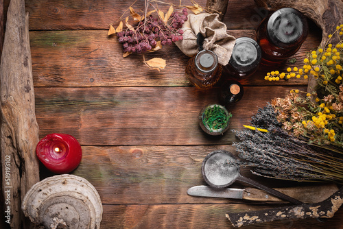 Herbal medicine concept background. Dry natural ingredients and remedy bottle on the wooden table flat lay background with copy space.