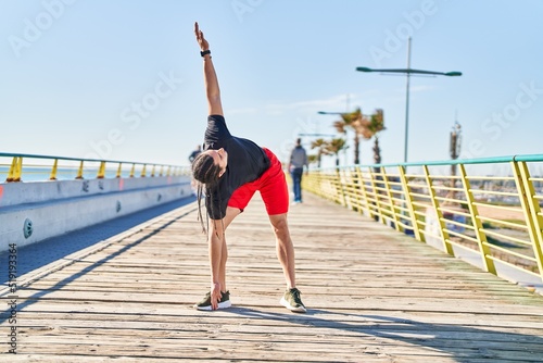Young man stretching at seaside