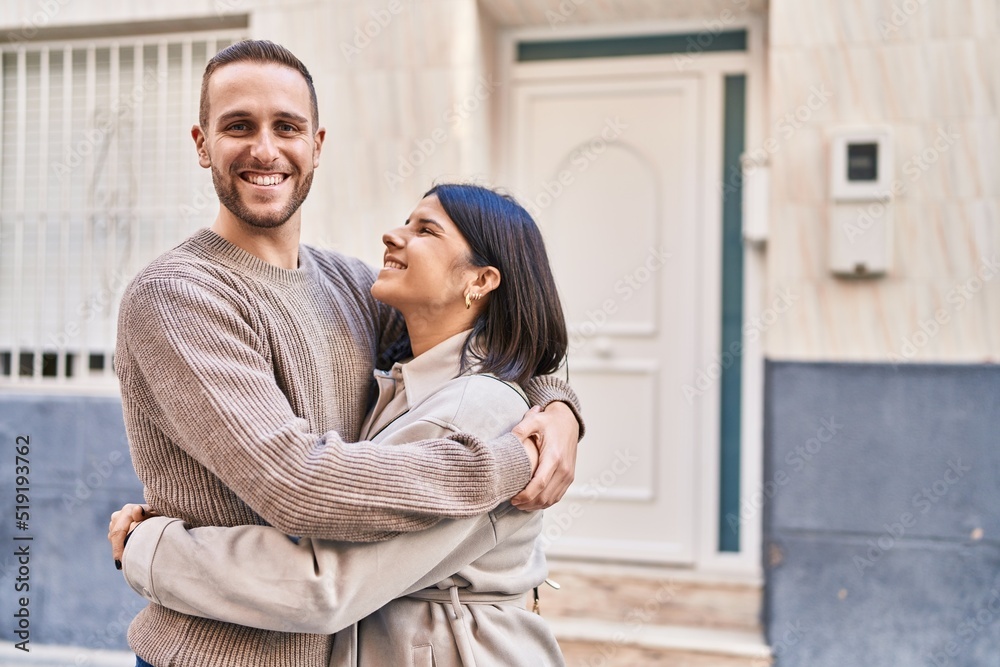 Man and woman couple smiling confident hugging each other standing at street Man and woman couple smiling confident hugging each other standing at street