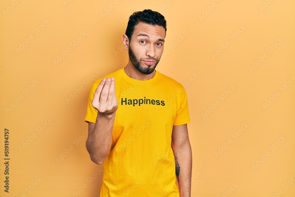 Hispanic man with beard wearing t shirt with happiness word message doing italian gesture with hand and fingers confident expression
