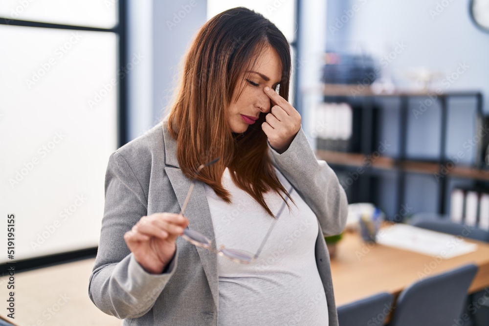 Fototapeta premium Young pregnant woman business worker stressed standing at office