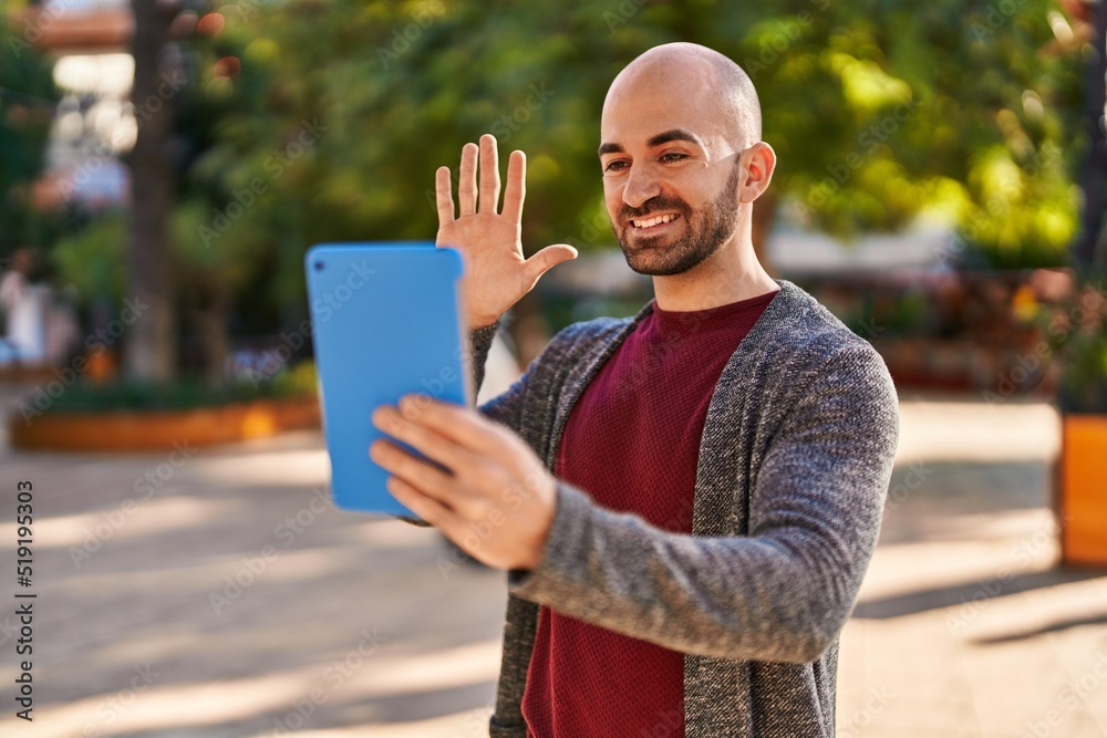 Fototapeta premium Young man smiling confident having video call at park