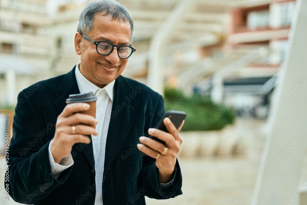 Middle age southeast asian man smiling using smartphone and drinking a cup of coffee at the city