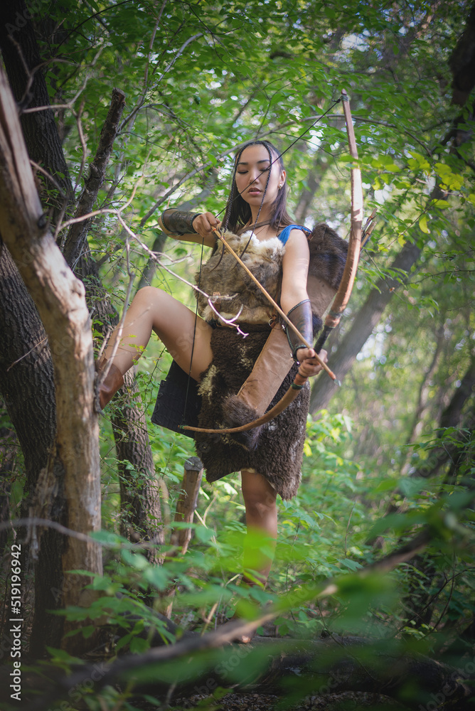 Beautiful asian woman an archer with the bow is hunting in the forest concept.