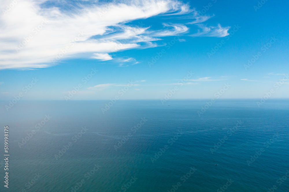 Aerial view of Blue sea with waves and sky with clouds. Ocean skyline.