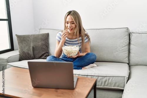 Young chinese woman smiling confident watching movie at home