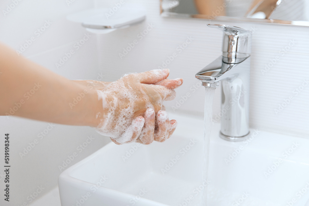 Washing hands under the flowing water tap. Hygiene concept hand detail. Washing hands rubbing with soap for corona virus prevention, hygiene to stop spreading corona virus in or public wash room. Washing hands under the flowing water tap. Hygiene concept hand detail. Washing hands rubbing with soap for corona virus prevention, hygiene to stop spreading corona virus in or public wash room.