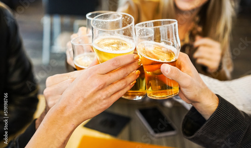 Friends showing hands while holding glasses of beer and cheering with each other - Lifestyle concept