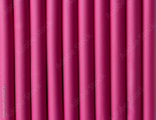 Abstract Background of Pink Rubber Pipes. Pink rubber tubes for decoration. Pink hair curlers, closeup. Selective focus. Colorful curlers for hairdress. Cylinders lined up in a row.