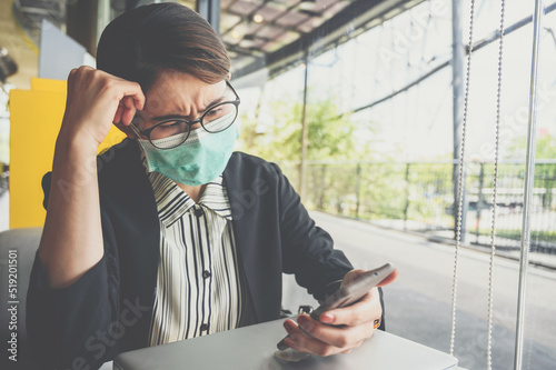 Asian businesswoman having stressed while looking badnews from her mobile phone. Conceptual shot of woman having negative feelings. photo